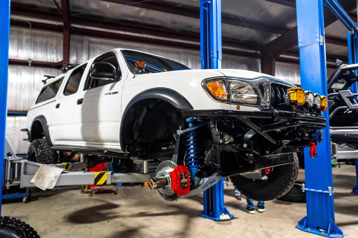 Lifted truck on the two-post lift for a lift kit install