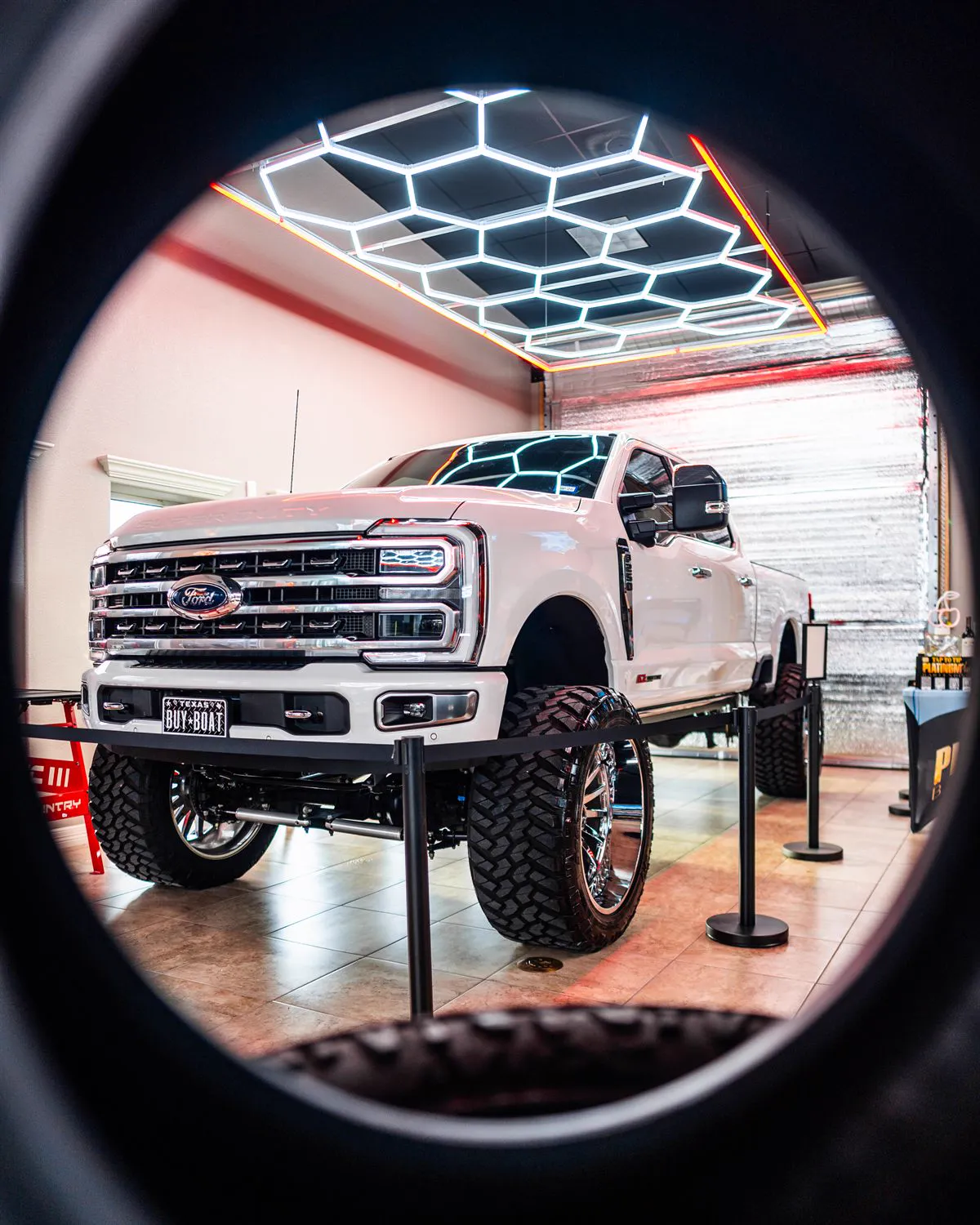 Lifted white Ford Super Duty Platinum on chrome wheels and mud tires